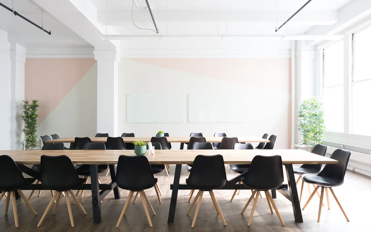Empty meeting room with a long table and black chairs